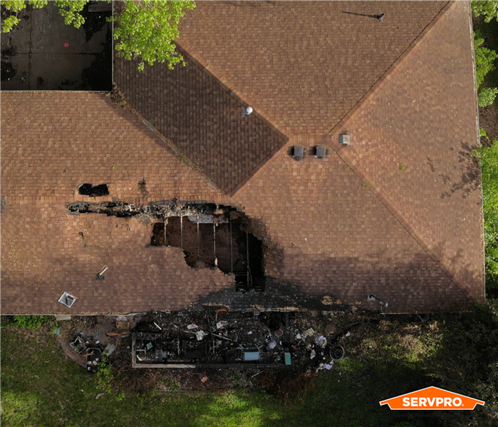 building with hole in roof from fire, aerial view of a brown roof of a large building after electrical fire